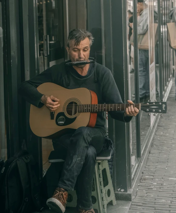 a man plays his guitar and sings on a porch