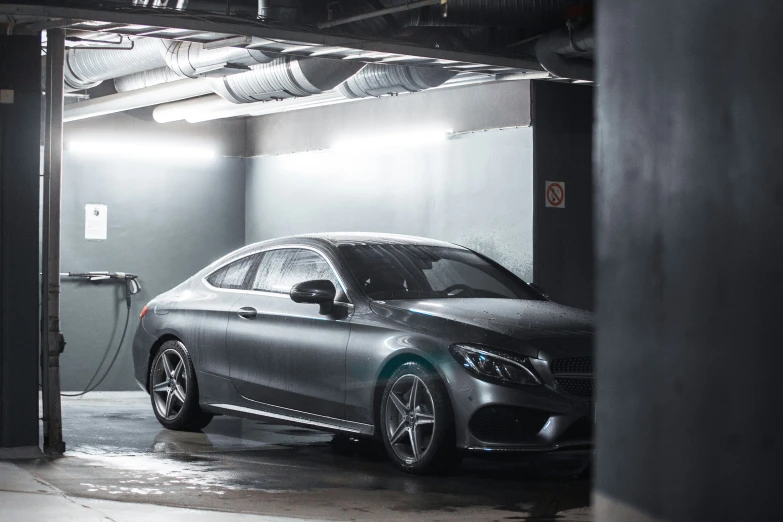 a dark colored mercedes in an empty garage