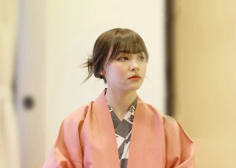 an asian woman in pink clothes looking away