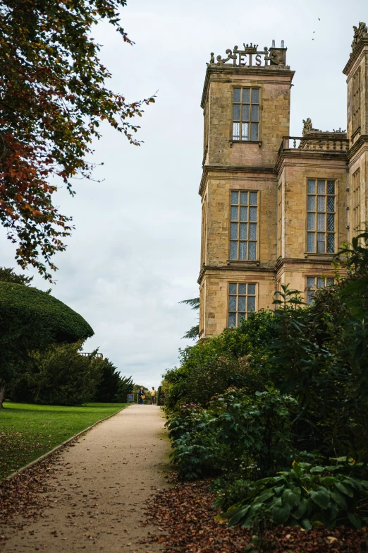 a large stone building sitting next to a green forest