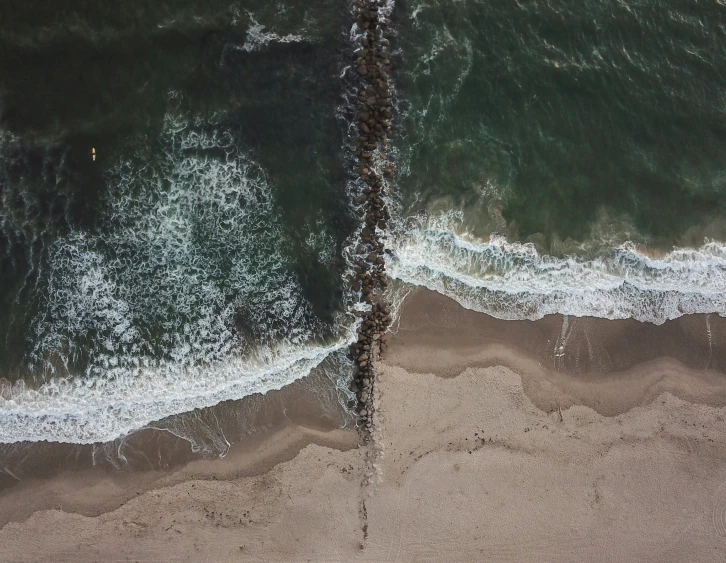 water crashing into beach and land behind it