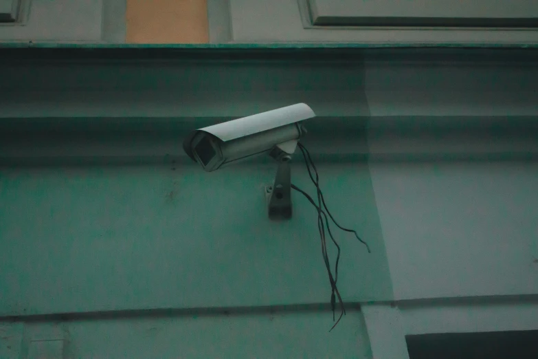 a video camera is hanging on the side of the house