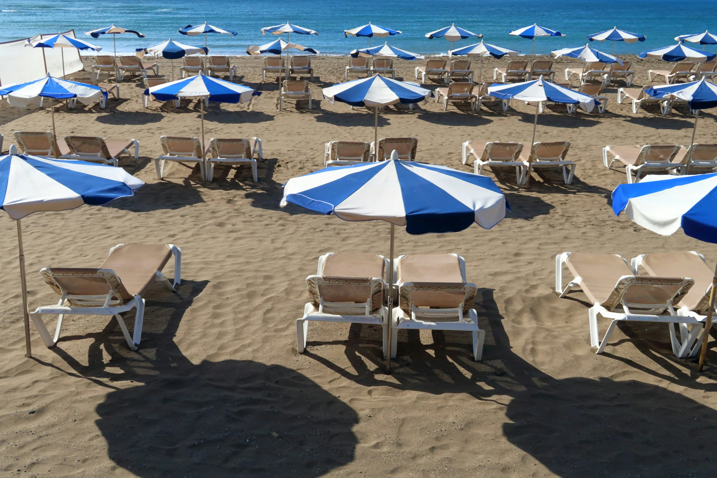 beach umbrellas and chairs on the sand at the ocean