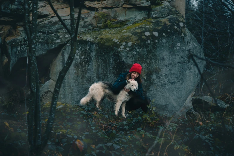 a woman is holding a white dog and posing for a picture