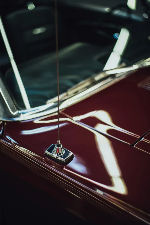 a red car with its hood open and the sun shining through the windows