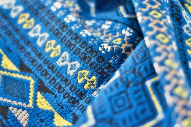 an intricate blue and yellow wool scarf, close - up