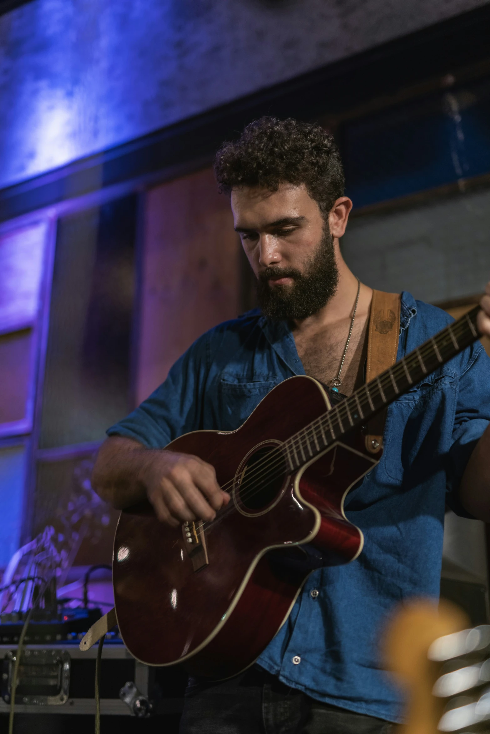 a man is playing an acoustic guitar at a music festival