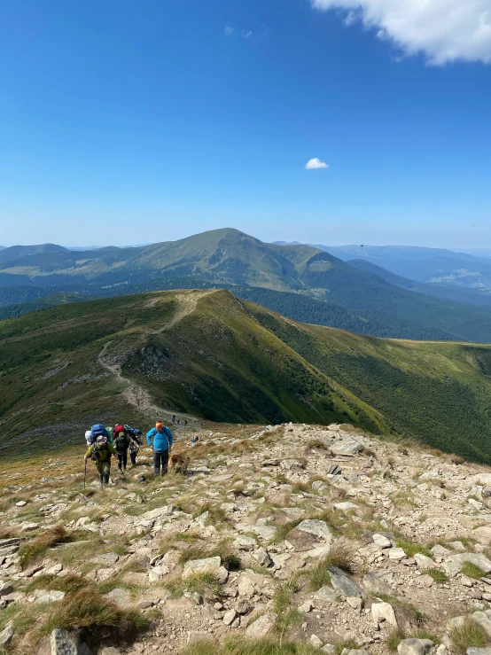 the three hikers look out at a valley below