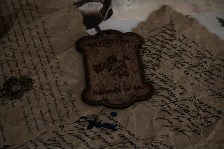 a piece of wood with writing is sitting on top of paper