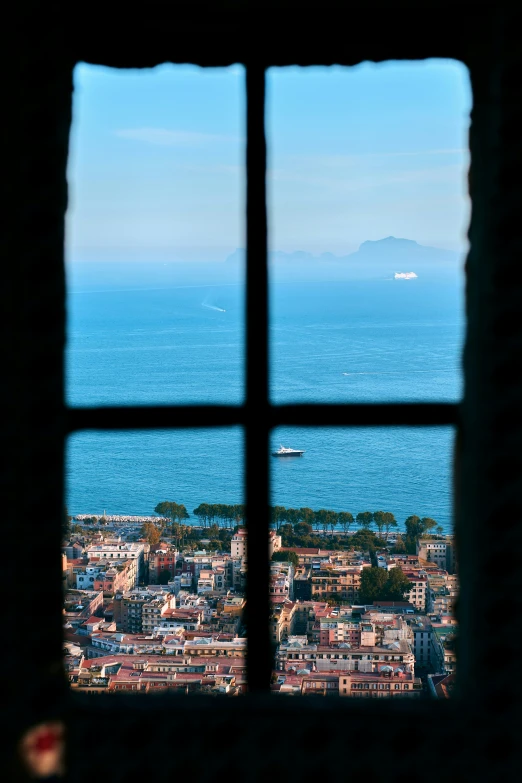 the view out of a window at a city by the sea