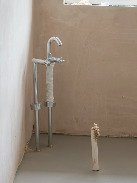 a bathroom with a sink and toilet paper roll on the floor