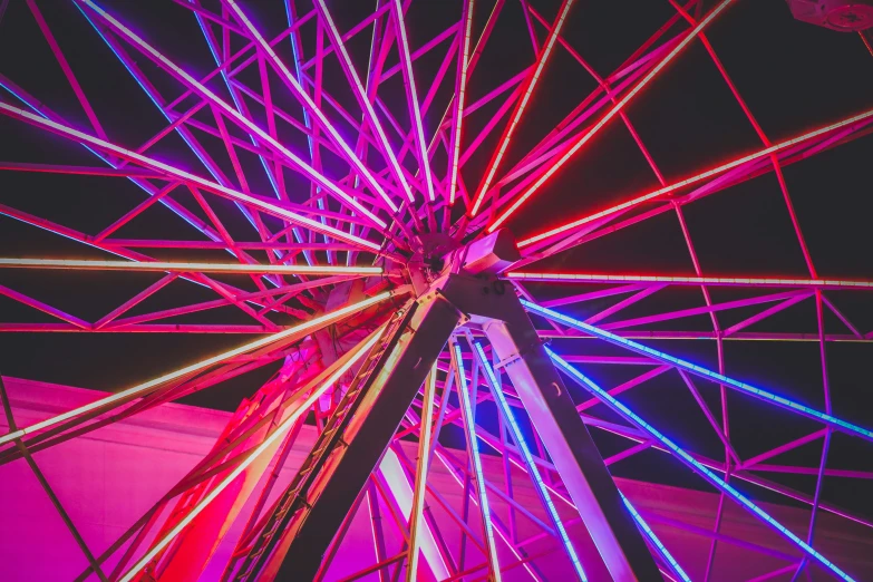 the inside of a ferris wheel, illuminated in colorful lights