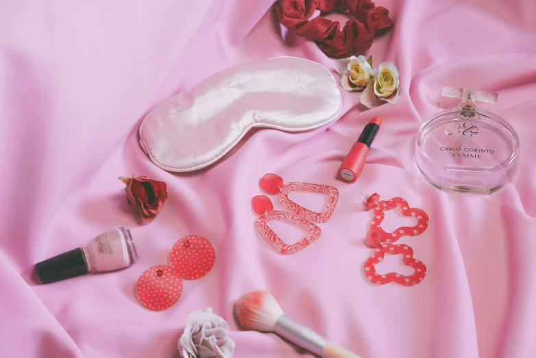 several different makeup items laying on top of a bed