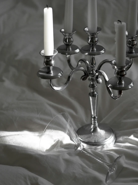 a candela with a single candle sits on a cloth