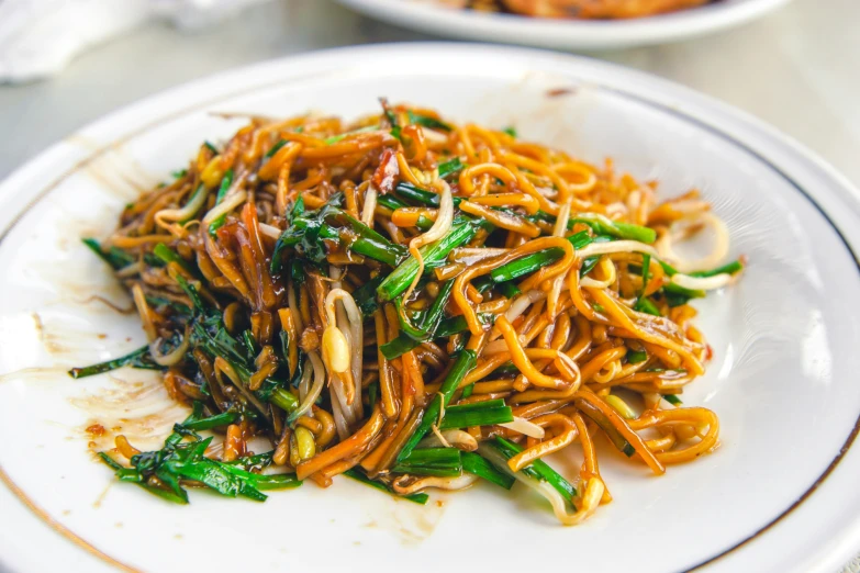 noodle dish on plate with other foods around it