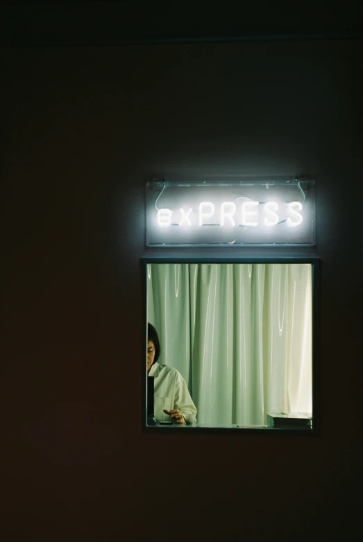 a woman sitting at a counter in front of a mirror