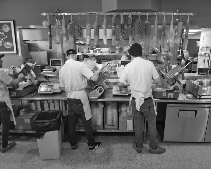 three workers in an assembly line at the counter