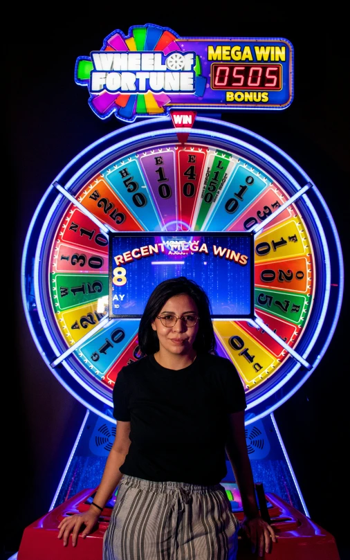 a woman standing next to a brightly colored wheel