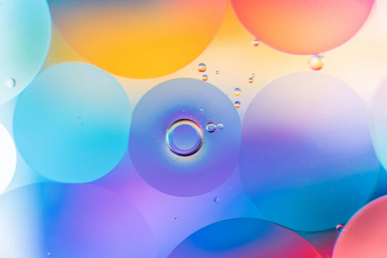 the drop of water that is in front of colorful circles