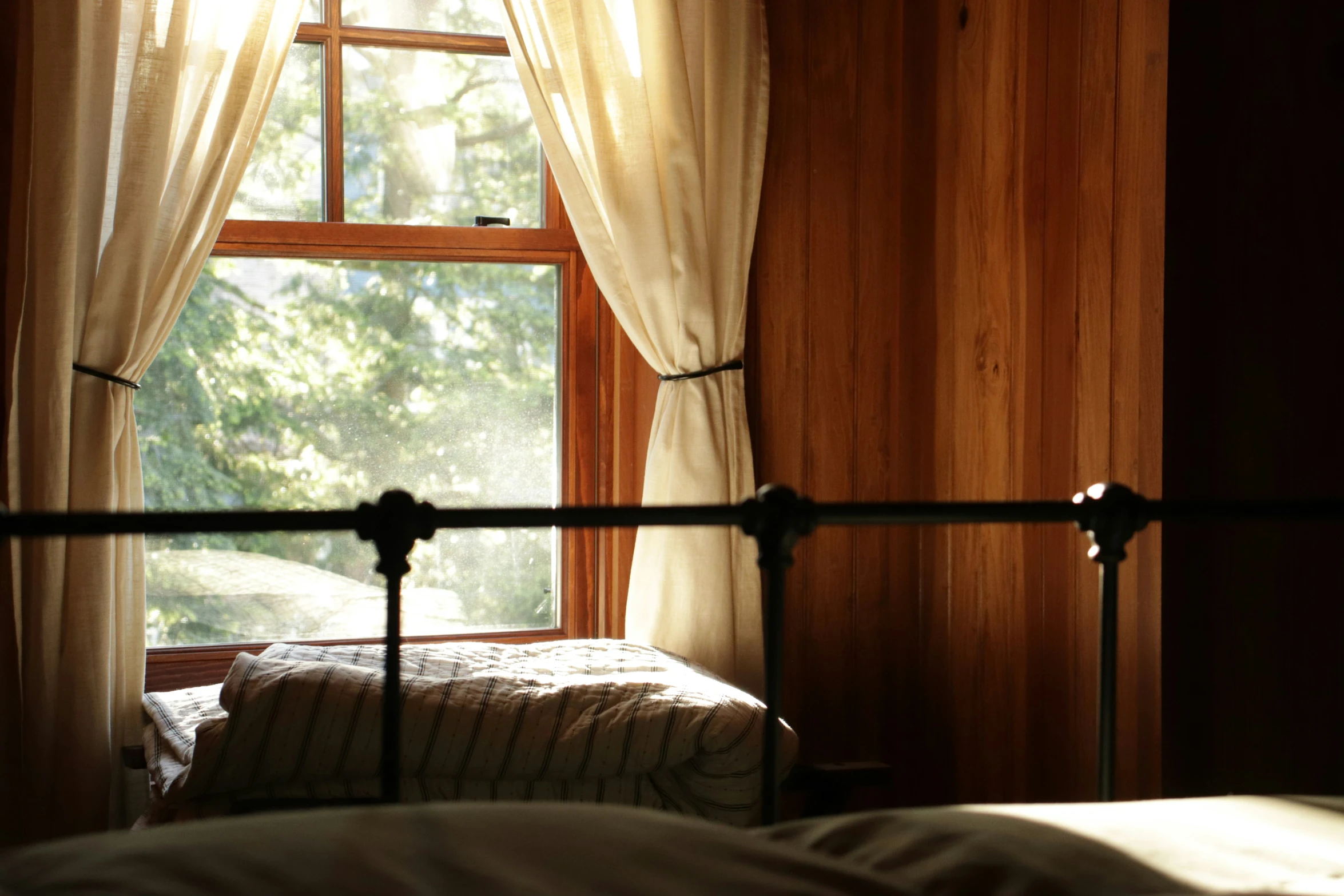 a window is opened in front of a bed