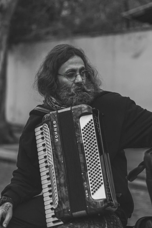 a man sitting down holding an accordion