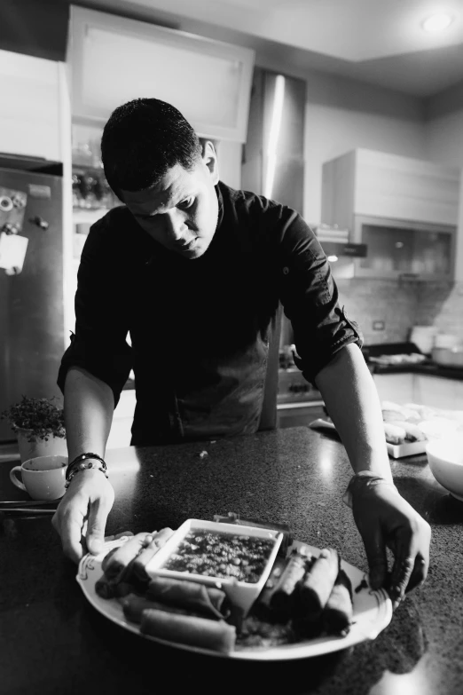 a man looks down as he makes sandwiches