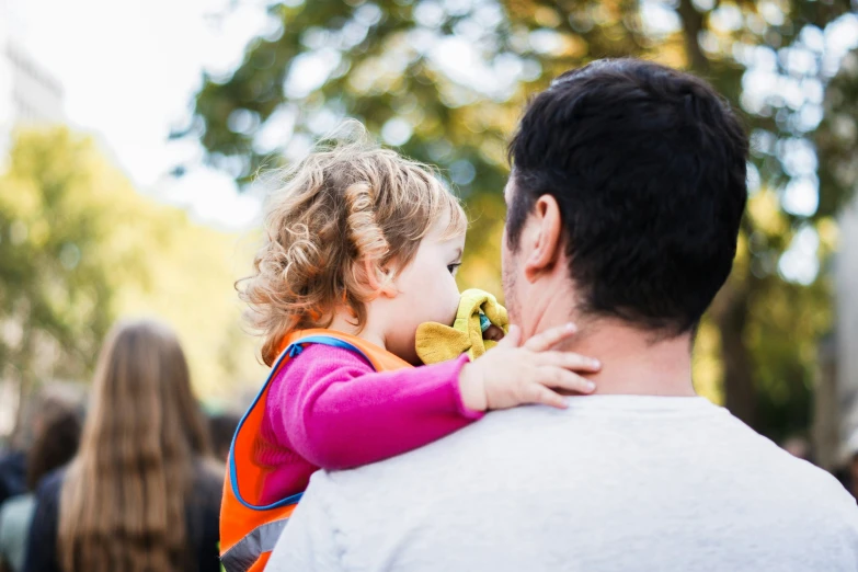 a man holding a small girl up in the air