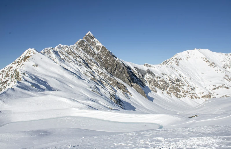 two people snowboarding on the top of a mountain