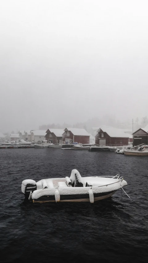 a small boat in the middle of a lake on a cold winter day