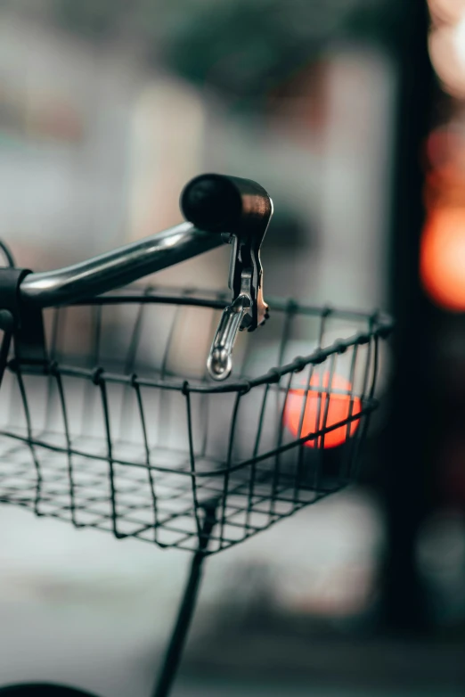 there is a small wire basket attached to a bike handle