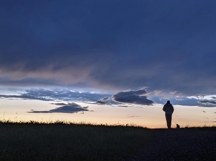 silhouette of man with arms in the air watching the sun set