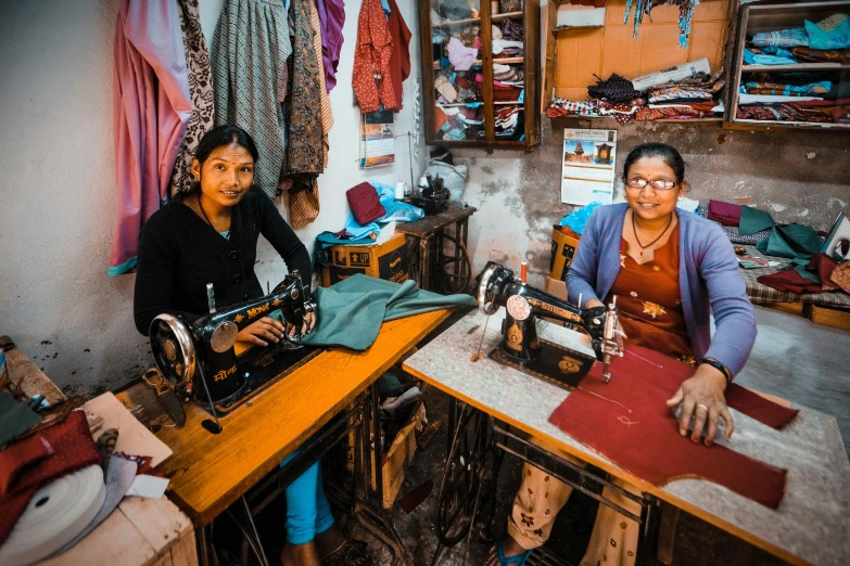 two women sitting in front of sewing machines