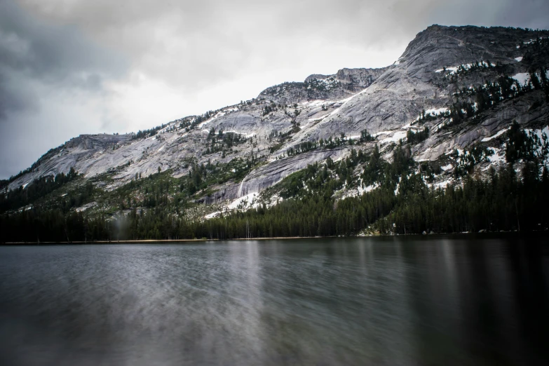 the mountains are covered in snow and green pine trees