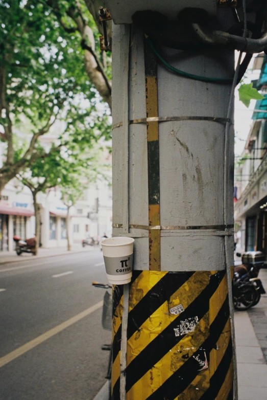 an old metal pole has a striped hazard sign on it