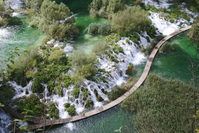 the water stream is running beside a boardwalk over a bridge