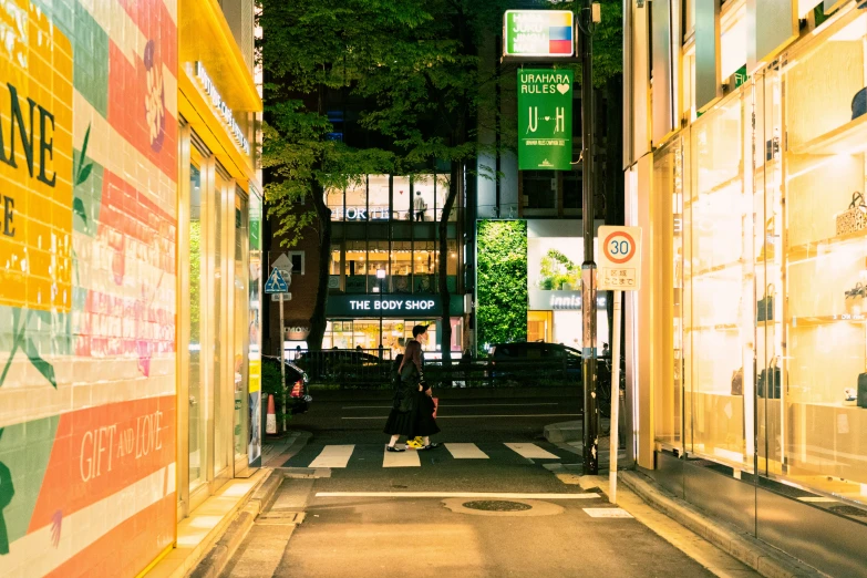 a couple of people crossing a street in an urban setting