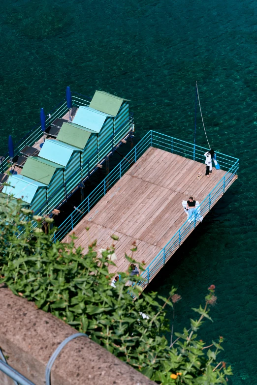 some people on the top of a pier by the water