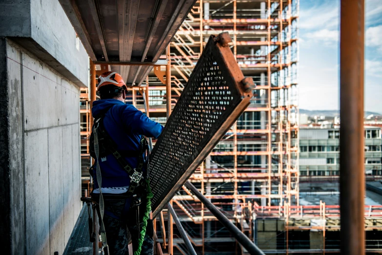 a man on a roof, repairing a scaffold