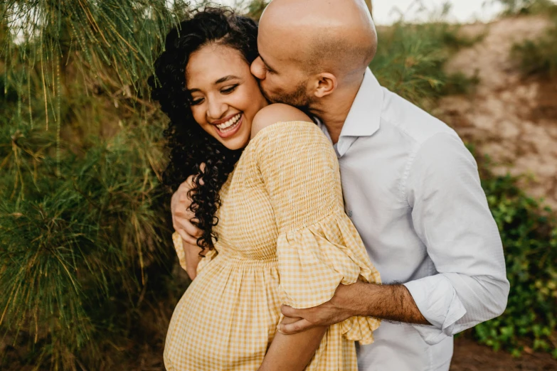 a woman is hugging a man while posing for a po