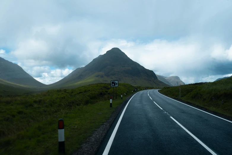 road winding in to mountains with clouds above