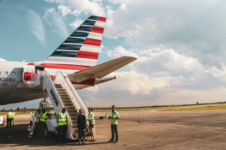 people are standing near an american airlines plane