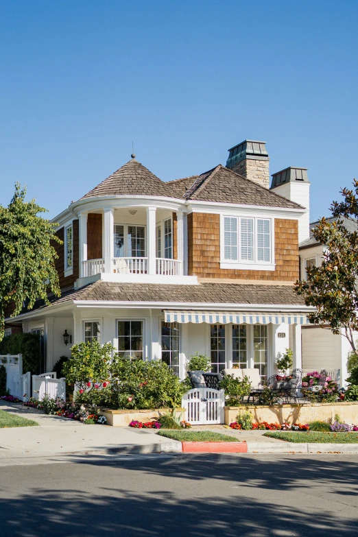 a big pretty home with a nice fence and tree in front