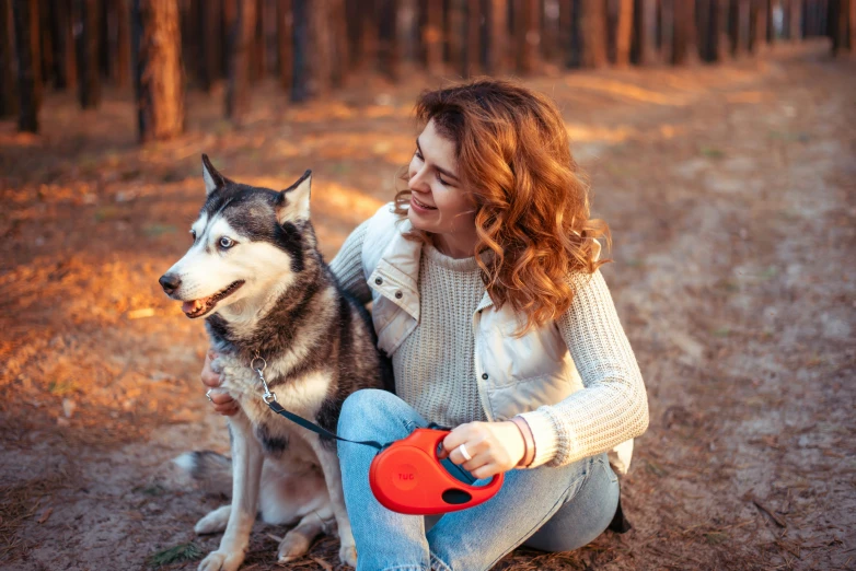 a person and a dog with trees in the background