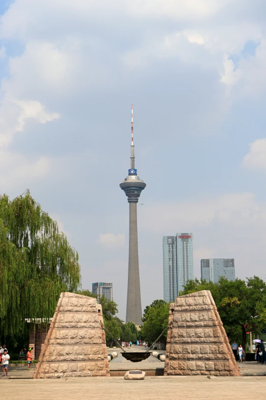 an empty park with three pyramids at the base of a spire