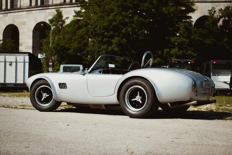 a vintage sports car sits parked by the curb