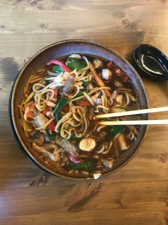 two chopsticks are in the bowl with noodles