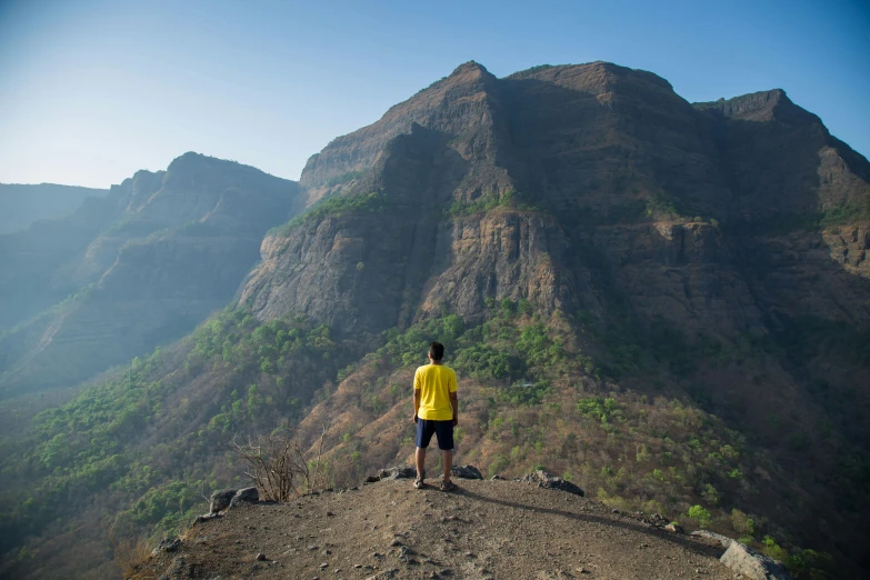 a person standing on a mountaintop with their arms behind his back