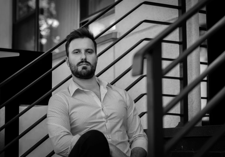 black and white pograph of a man sitting on the steps