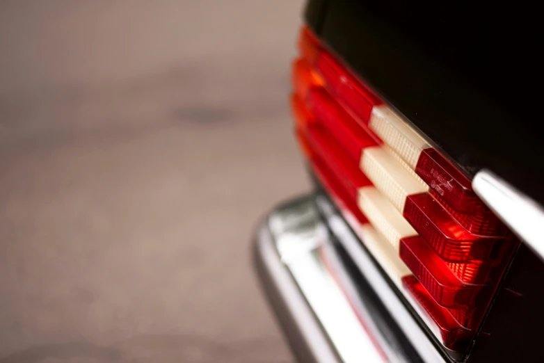 the back end of a black car with a white and red stripe