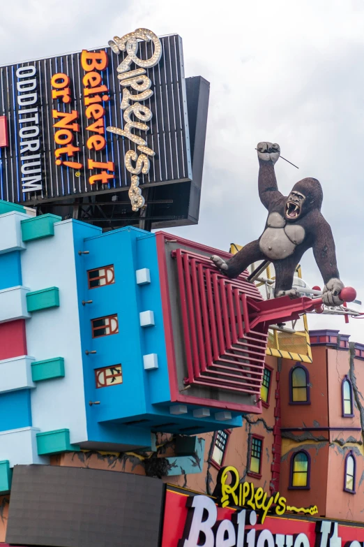 a large gorilla statue next to several colorful motels